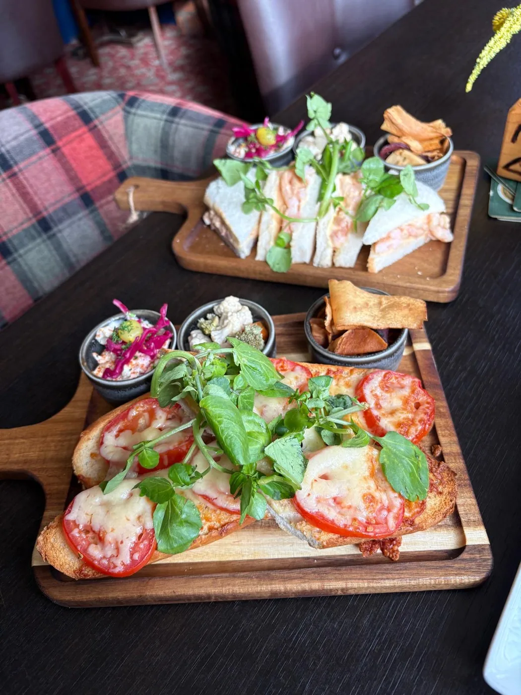 Tomato and cheese bruschetta board with a prawn sandwich board behind