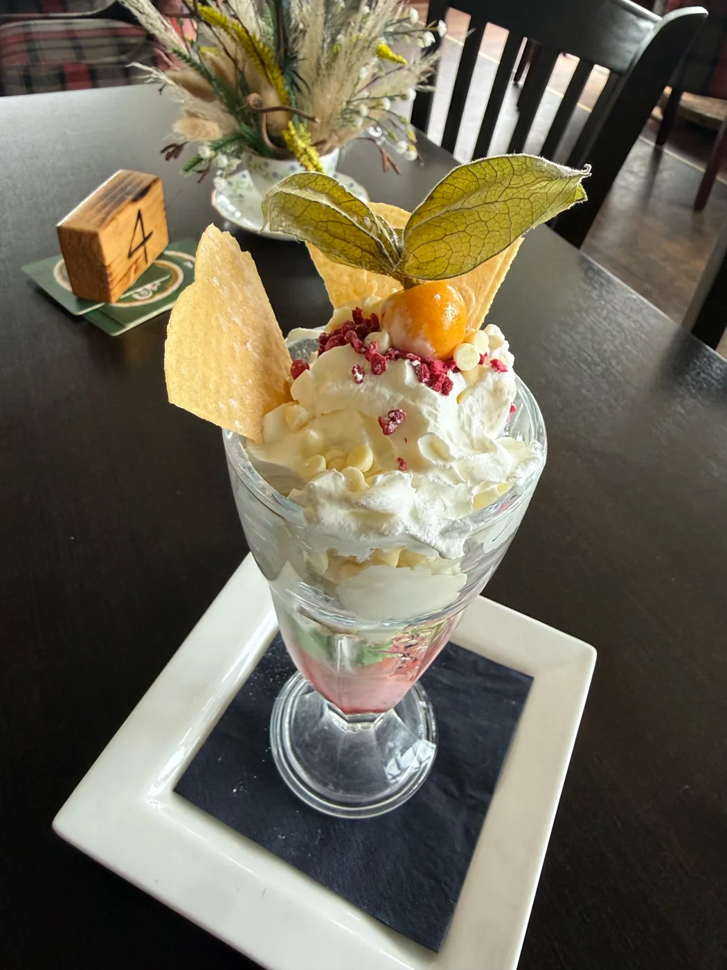 Ice cream sundae with cream, raspberry crumb and physalis